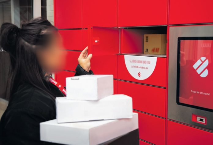 用户在stabox快递包裹储物柜前取物品