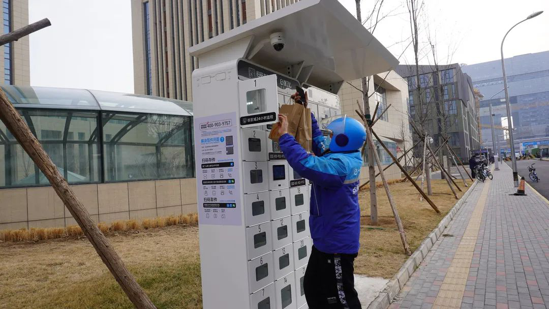 外卖员将外卖放入智能取餐柜